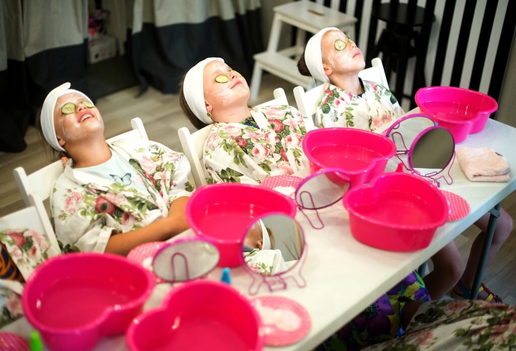Pamper parties for children in London with 3 girls with their heads leaning back being pampered